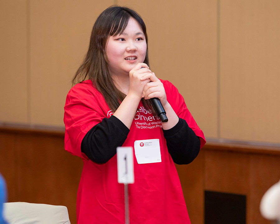 A student talking and holding a microphone