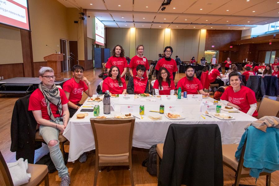 Table with 11 Deliberation Dinners students wearing red teeshirts