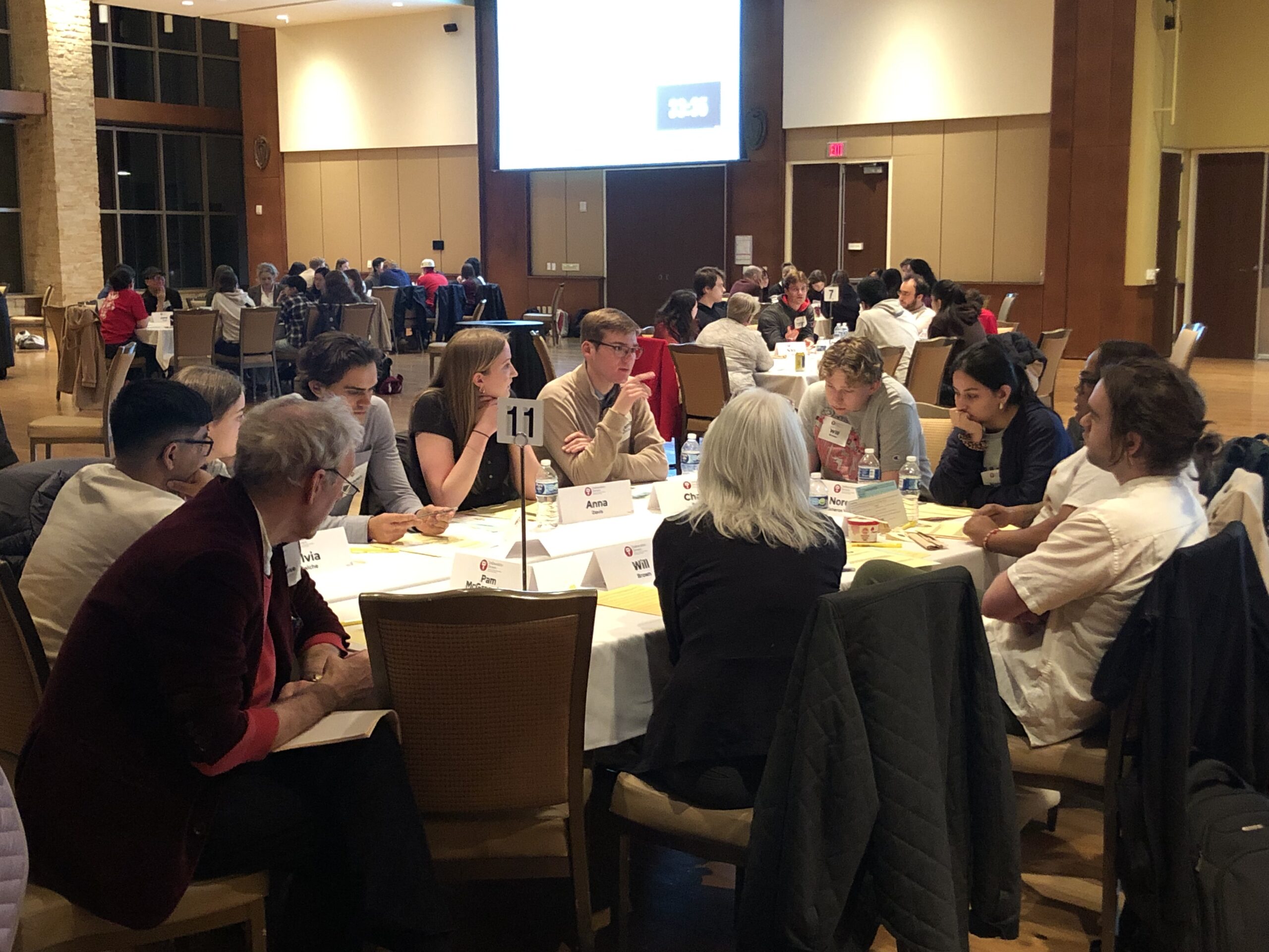 9 participants discuss at a table with 2 facilitators